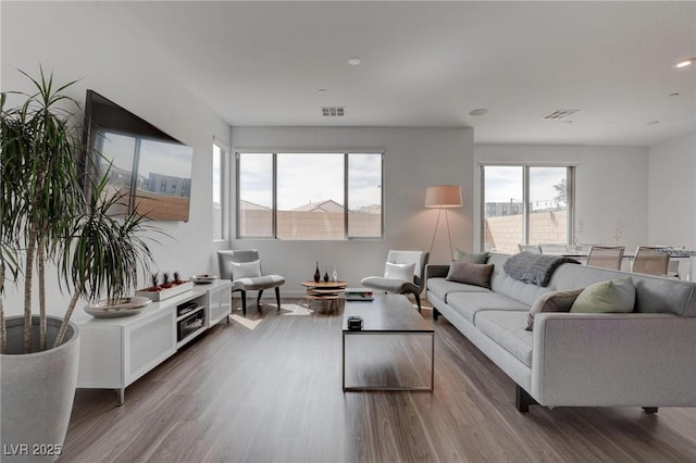 living area with visible vents and wood finished floors