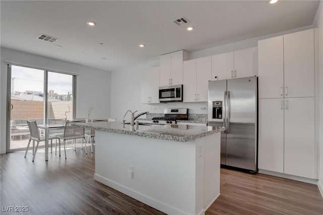 kitchen with a sink, visible vents, wood finished floors, and stainless steel appliances