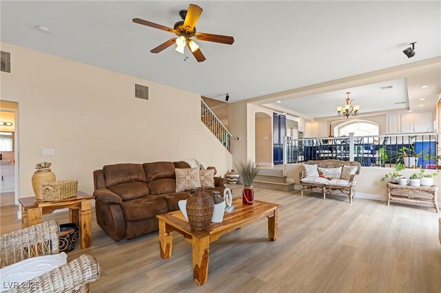 1430 October Oak Ave, Las Vegas, NV 89123 - living room featuring stairs, visible vents, light wood-type flooring, and ceiling fan with notable chandelier