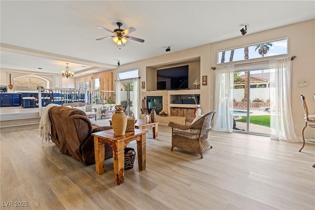 1430 October Oak Ave, Las Vegas, NV 89123 - living area with ceiling fan with notable chandelier, light wood finished floors, and a tile fireplace