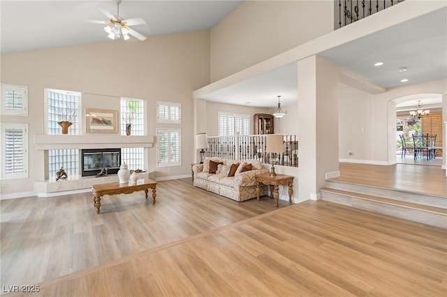 1430 October Oak Ave, Las Vegas, NV 89123 - living room featuring wood finished floors, high vaulted ceiling, baseboards, and ceiling fan with notable chandelier