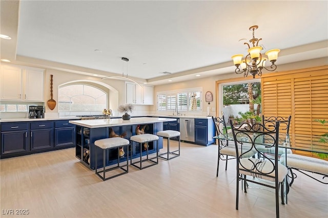 1430 October Oak Ave, Las Vegas, NV 89123 - kitchen with blue cabinetry, a kitchen island, a chandelier, dishwasher, and light countertops
