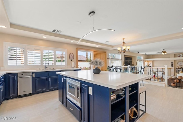 1430 October Oak Ave, Las Vegas, NV 89123 - kitchen with stainless steel microwave, blue cabinets, light countertops, visible vents, and a sink