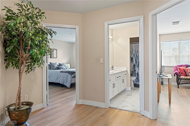 1430 October Oak Ave, Las Vegas, NV 89123 - hallway featuring light wood finished floors, visible vents, baseboards, and a sink