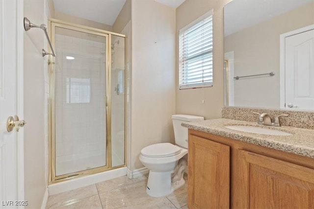 full bath with a stall shower, baseboards, toilet, tile patterned floors, and vanity