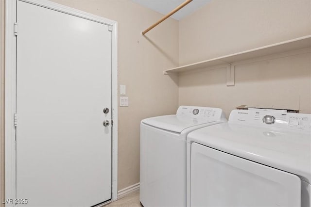 washroom with washer and clothes dryer, baseboards, and laundry area