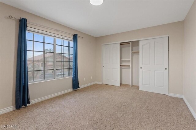 unfurnished bedroom featuring a closet, carpet, and baseboards