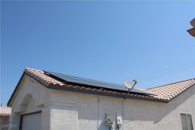 details featuring a tiled roof and stucco siding