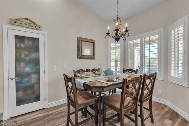 dining room featuring baseboards, wood finished floors, and a chandelier