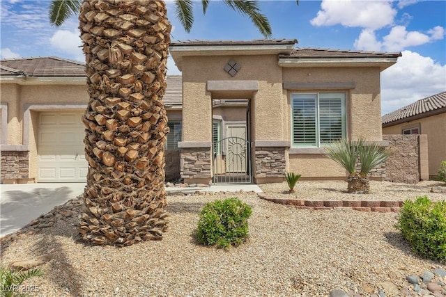 view of front of property with a garage, driveway, stone siding, and stucco siding