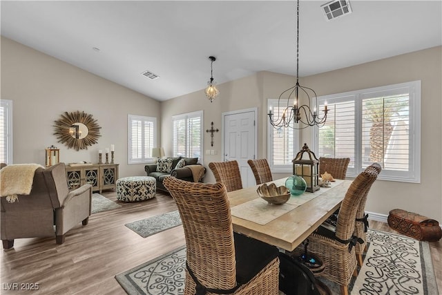 dining room with visible vents, wood finished floors, and a chandelier