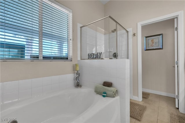 bathroom with a shower stall, a garden tub, and tile patterned flooring