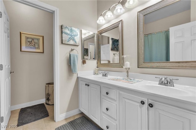 bathroom featuring baseboards, tile patterned flooring, a sink, and double vanity