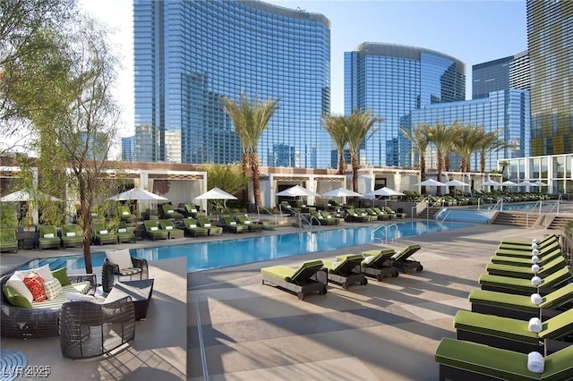 community pool featuring a skyline view and a patio area