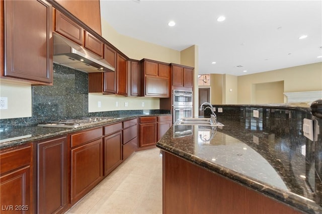 1111 Casa Palermo Cir, Henderson, NV 89011 - kitchen with a sink, under cabinet range hood, stainless steel appliances, backsplash, and light tile patterned flooring