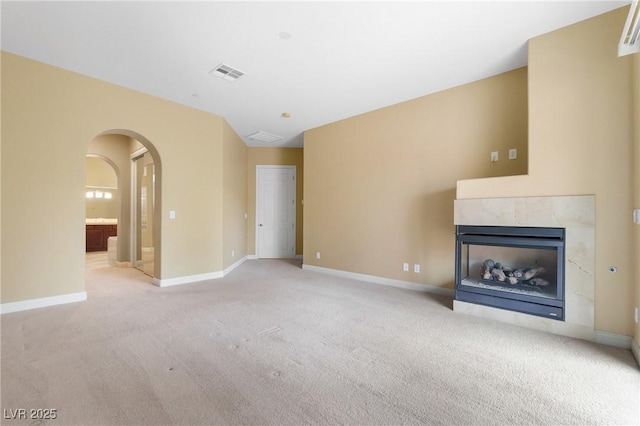 1111 Casa Palermo Cir, Henderson, NV 89011 - unfurnished living room featuring light carpet, arched walkways, visible vents, and baseboards