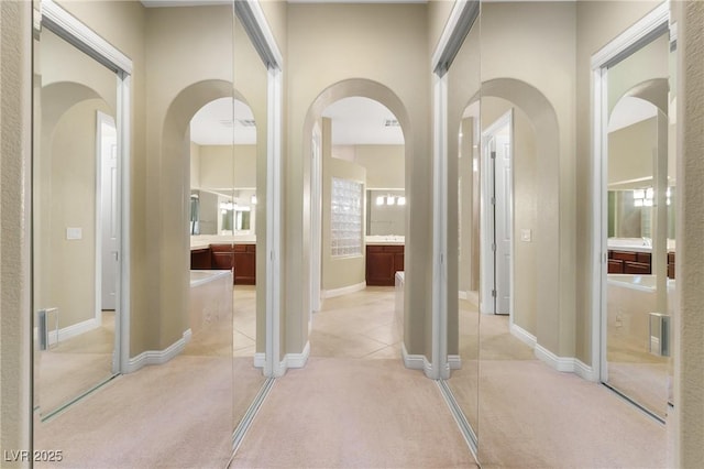1111 Casa Palermo Cir, Henderson, NV 89011 - hallway featuring visible vents, baseboards, arched walkways, and light carpet