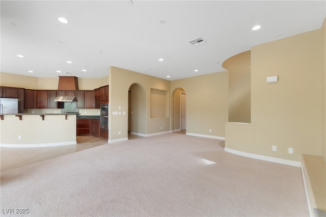 1111 Casa Palermo Cir, Henderson, NV 89011 - unfurnished living room featuring baseboards, light carpet, recessed lighting, visible vents, and arched walkways