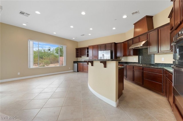 1111 Casa Palermo Cir, Henderson, NV 89011 - kitchen featuring light tile patterned floors, dark countertops, under cabinet range hood, visible vents, and appliances with stainless steel finishes