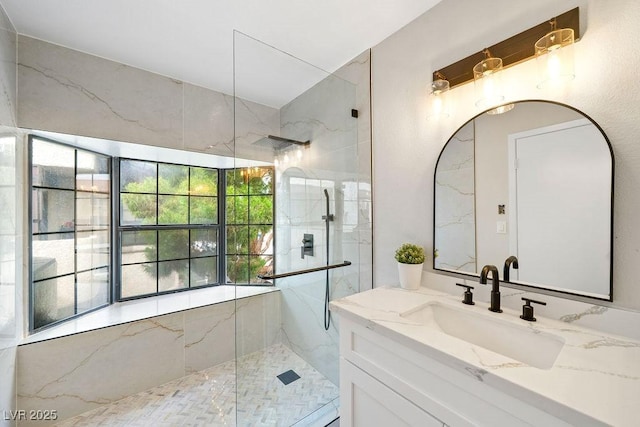 bathroom with vanity and a marble finish shower