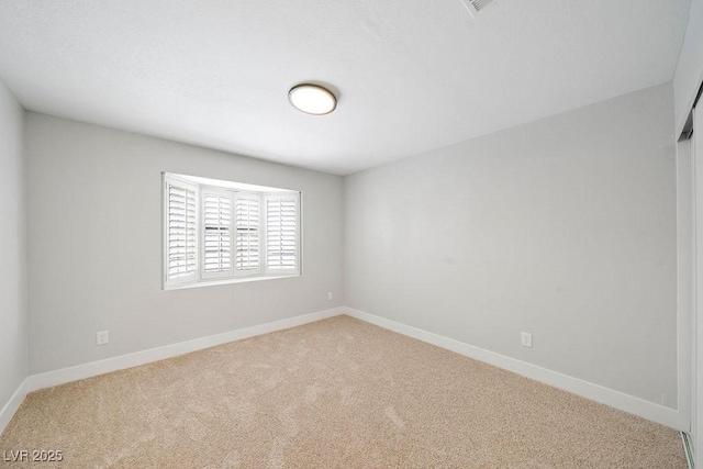empty room featuring carpet flooring and baseboards