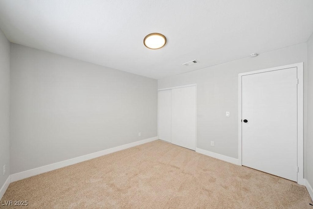 unfurnished bedroom with a closet, visible vents, carpet flooring, and baseboards