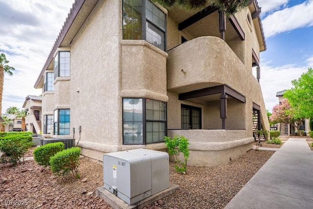 rear view of house featuring stairway and stucco siding
