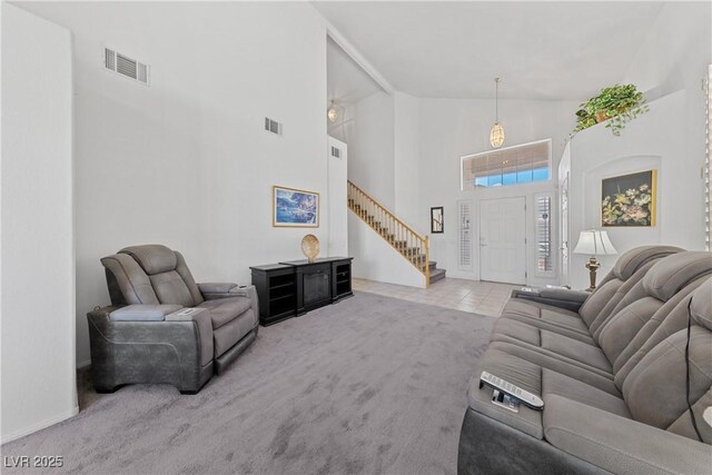 3024 Pismo Beach Dr, Las Vegas, NV 89128 - carpeted living room with high vaulted ceiling, stairs, tile patterned flooring, and baseboards