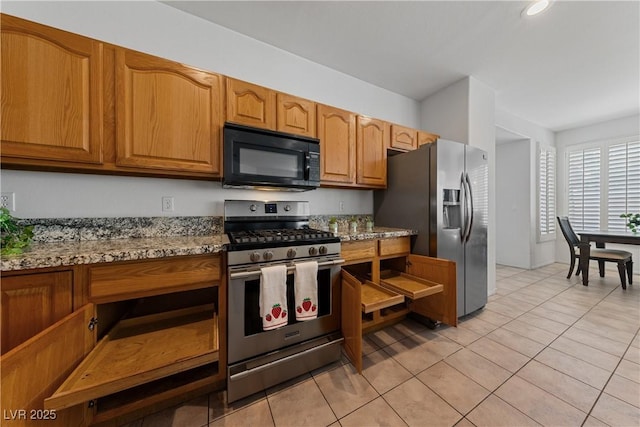 3024 Pismo Beach Dr, Las Vegas, NV 89128 - kitchen featuring appliances with stainless steel finishes, light tile patterned floors, brown cabinetry, and light stone countertops