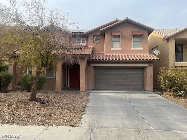 mediterranean / spanish house featuring concrete driveway, stucco siding, solar panels, a garage, and a tiled roof