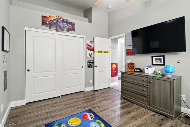 bedroom featuring baseboards, dark wood finished floors, and a closet