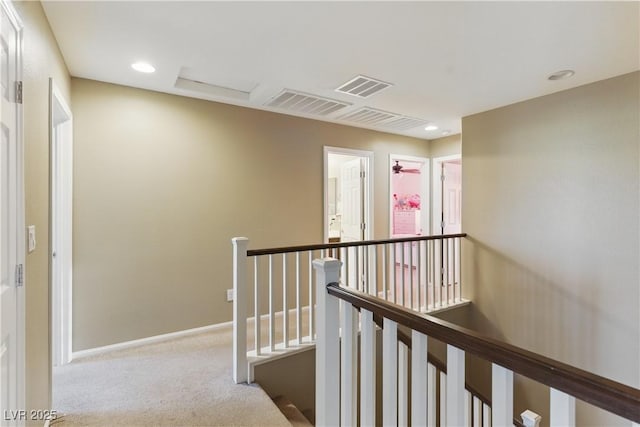 corridor featuring carpet floors, baseboards, an upstairs landing, and visible vents