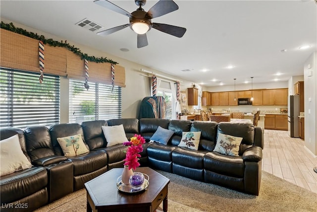 living area featuring a ceiling fan, recessed lighting, and visible vents