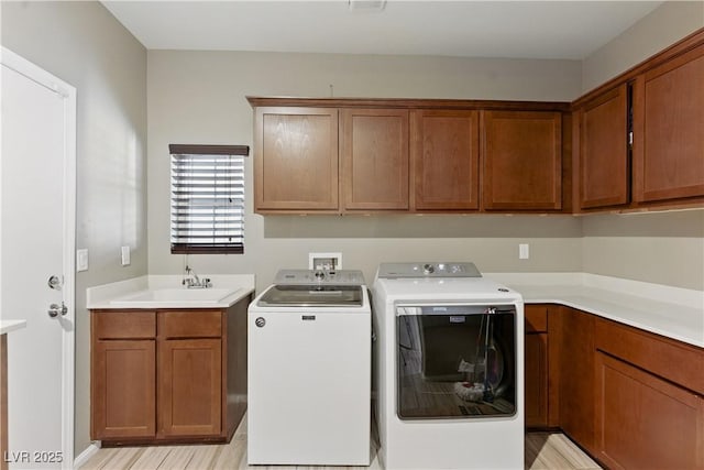 clothes washing area with cabinet space, separate washer and dryer, and a sink
