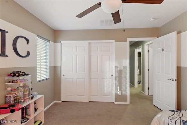 bedroom with baseboards, light colored carpet, ceiling fan, and visible vents