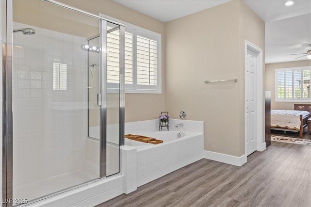 bathroom featuring connected bathroom, baseboards, a shower stall, and wood finished floors