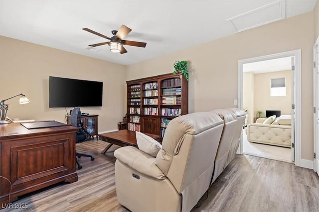 office featuring attic access, light wood-style floors, and a ceiling fan