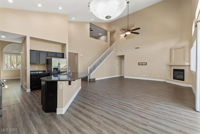 4212 Hawks Glide Ave, North Las Vegas, NV 89084 - kitchen with stainless steel fridge, open floor plan, wood finished floors, a high ceiling, and a glass covered fireplace