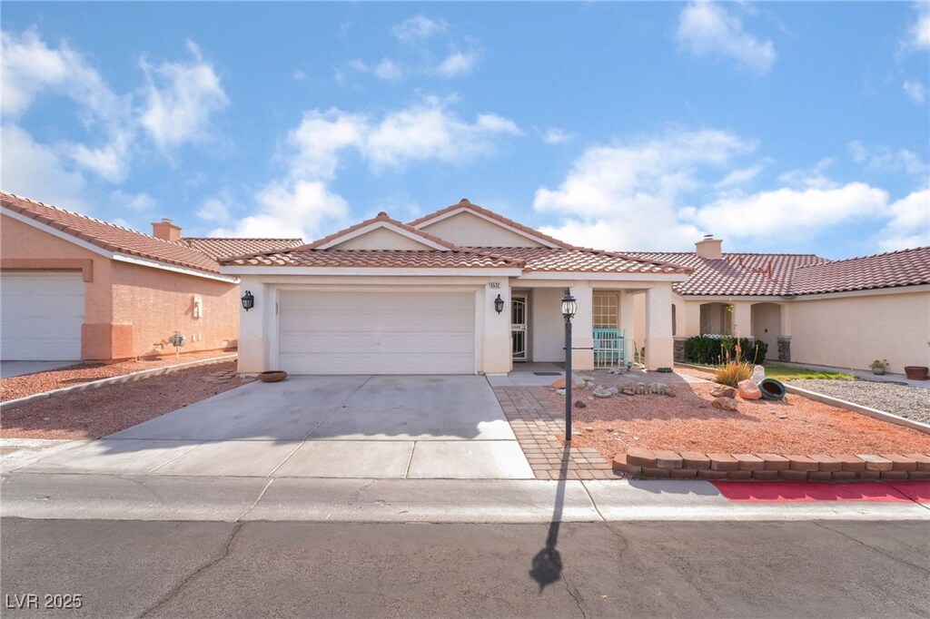 5532 Sentinel Bridge St, Las Vegas, NV 89130 - mediterranean / spanish-style home featuring driveway, stucco siding, an attached garage, and a tile roof