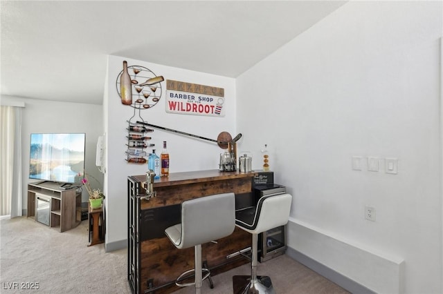 carpeted home office with a dry bar and baseboards