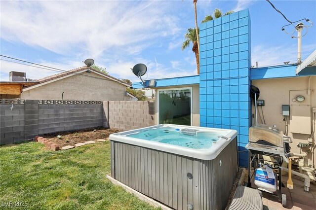 view of yard with central AC unit, fence, and a hot tub