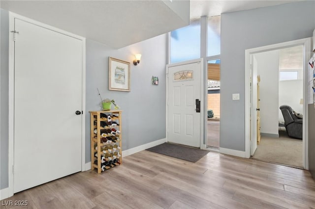 foyer with light wood-style floors and baseboards