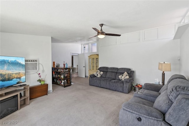 living area with carpet floors, a wall unit AC, and ceiling fan