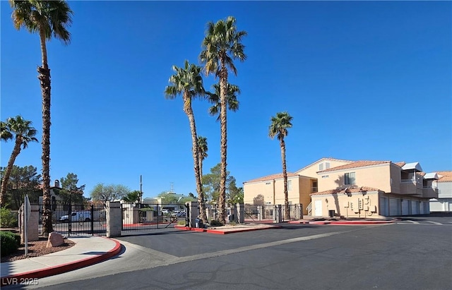 8452 Boseck Dr Unit 216, Las Vegas, NV 89145 - view of asphalt road featuring sidewalks, curbs, a gate, a residential view, and a gated entry