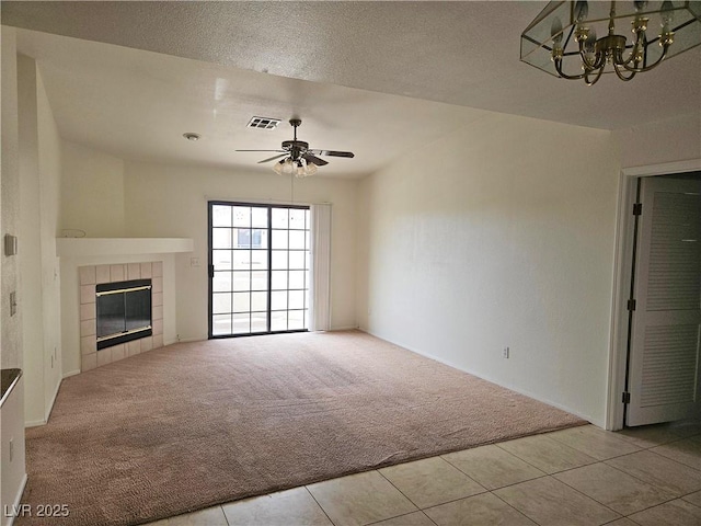 8452 Boseck Dr Unit 216, Las Vegas, NV 89145 - unfurnished living room with carpet flooring, a ceiling fan, a tiled fireplace, a chandelier, and tile patterned floors