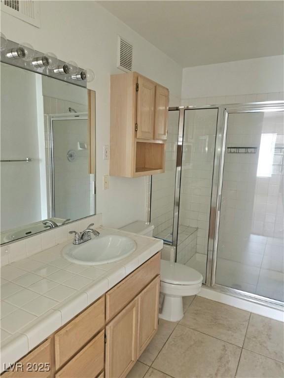 8452 Boseck Dr Unit 216, Las Vegas, NV 89145 - bathroom with toilet, a shower stall, vanity, and tile patterned flooring