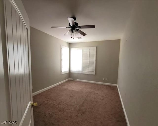 carpeted spare room featuring ceiling fan, baseboards, and visible vents