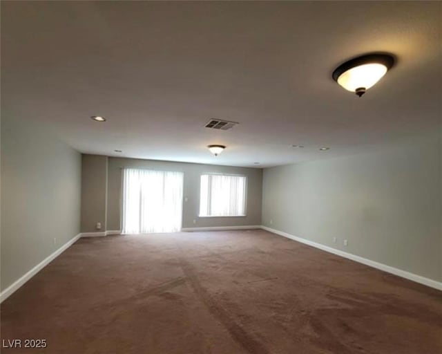 carpeted spare room featuring baseboards, visible vents, and recessed lighting