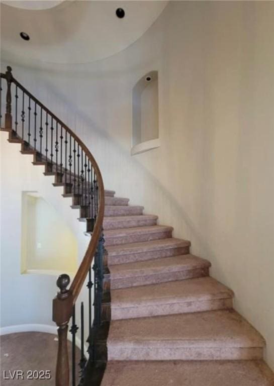 staircase featuring carpet and baseboards