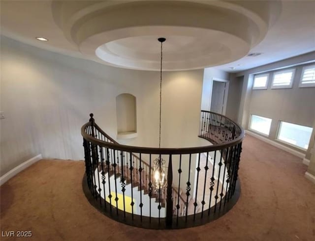 corridor featuring baseboards, recessed lighting, an upstairs landing, carpet floors, and a raised ceiling